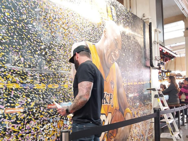 אמן בפינישים אחרונים לציור קיר בשוק האוכל הגדול של אל.איי, גרנד סנטרל מרקט