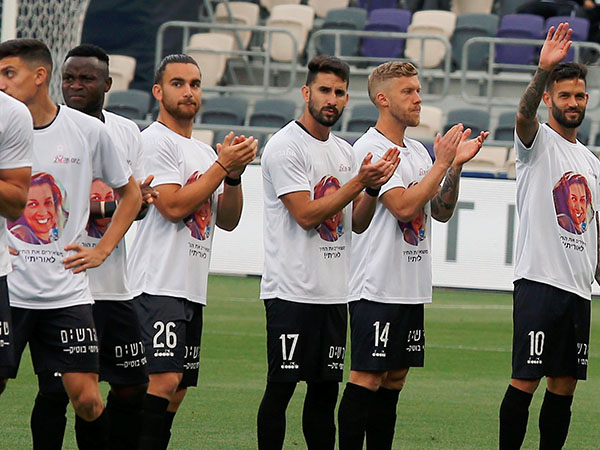השחקנים עולים למגרש עם פניה של אורית ממן על החולצות. מחווה מרגשת למשפחתו של קשר הפועל חיפה (אלן שיבר)
