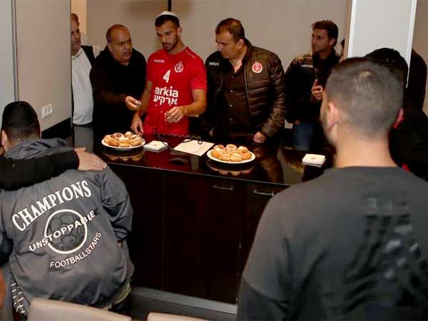 שחקני הפועל ת"א בהדלקת הנרות הערב (האתר הרשמי)