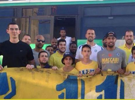 ברוכים הבאים. אוהדי מכבי ת"א עם השחקנים בנתב"ג (צילום: האר הרשמי של מכבי ת"א)