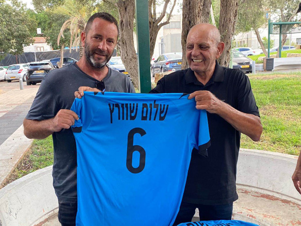 איש השיווק אריה מולייב העניק חולצה לכל שחקן. בתמונה יקיר שוורץ, מבעלי הפועל חדרה, מקבל את חולצת אביו שלום ז״ל
