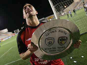 איתי שכטר עם צלחת האליפות של הפועל ת“א ב-2009/10. דרמה מארץ הדרמות