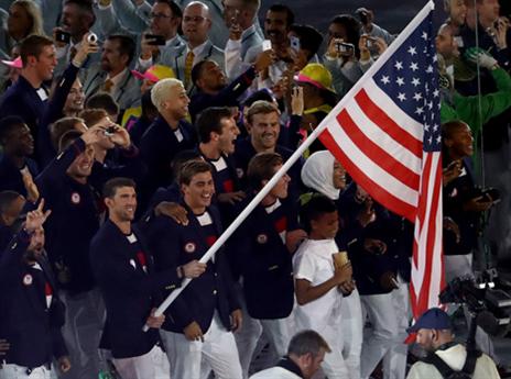 מייקל פלפס נושא את דגל ארה"ב בטקס (getty)