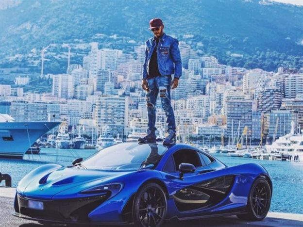 לואיס המילטון על תקרת מכונית מקלארן על רקע נופי מונאקו, אחת מתוך עשרות מכוניות באוסף הפרטי שלו (צילום מתוך דף האינסטגרם)