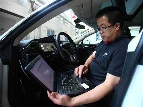 טכנאי של טסלה מבצע עדכונים לרכב (צילום: Getty)