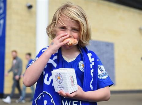 אוהד לסטר צעיר נהנה מסופגניה בחינם (Getty)