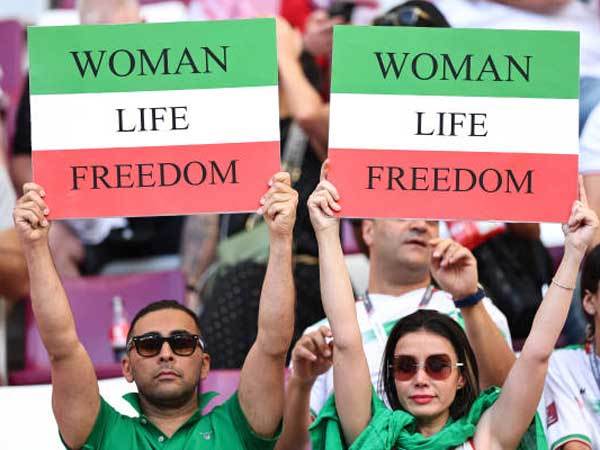 האוהדים האיראנים עם שלטים (GETTY)